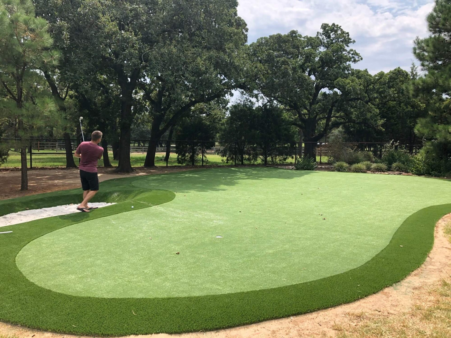 Golfer using backyard putting green