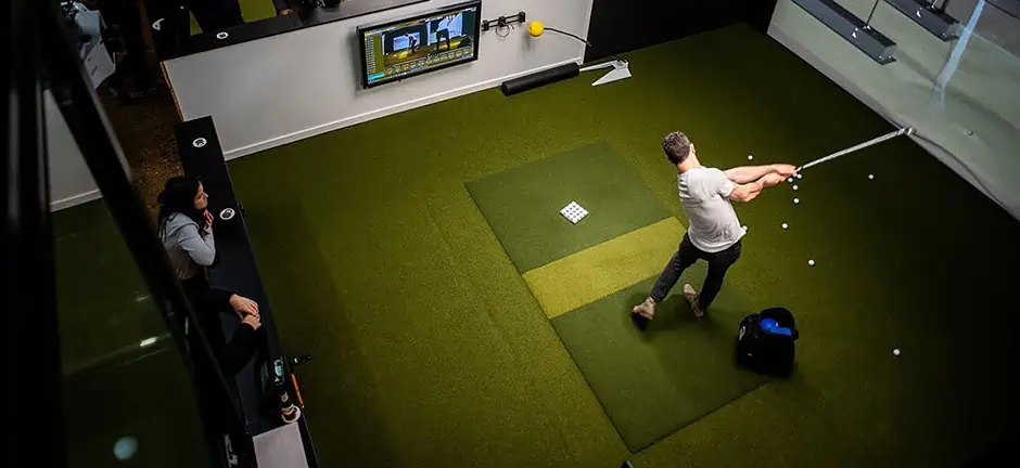 Golfer enjoying indoor virtual golf on artificial grass